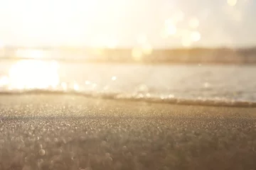 Deurstickers Zeegolven en warm zonsonderganglicht, rustig en ontspannend zandstrand © tomertu