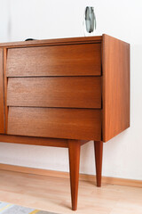 a vintage 60s mid century sideboard cupboard made out of teak wood in denmark standing in the living room danish design high quality decorated furnished 20s lamp