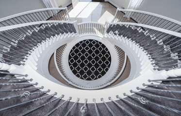 elegant stairs spiral down to lower level