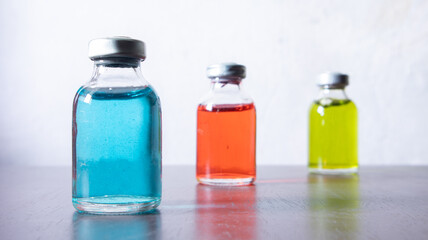 The red solution of drug vial is focused. three bottle have particulate matter.