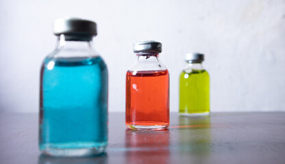 Medical reagent in the sterile vial that contained red, green, and blue solution. some vial contain particulate matter. the defection of pharmaceutical production. focusing at the middle.