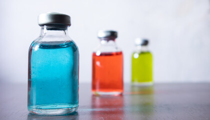 Medical reagent in the sterile vial that contained red, green, and blue solution. some vial contain particulate matter. the defection of pharmaceutical production. focusing at the left