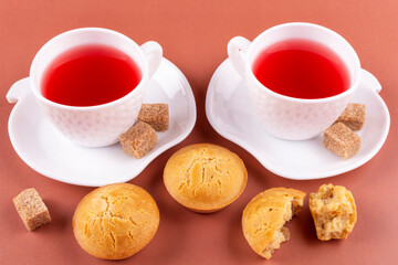 Two cups of delicious raspberry drink and homemade rice muffins on a brown (pink) background. Rice flour cupcakes. Breakfast with a gluten-free diet.