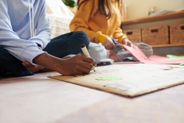 Close-up image of friends creating placard for climate change awareness campaign