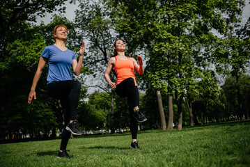 Women girlfriends exercising together outdoors