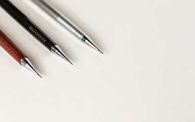Three mechanical pencils of different sizes on the white background.