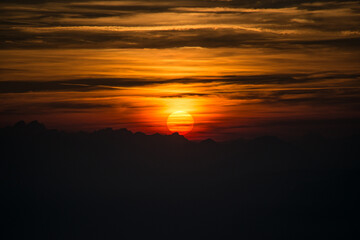 Sun silhouette at sunset in the mountains
