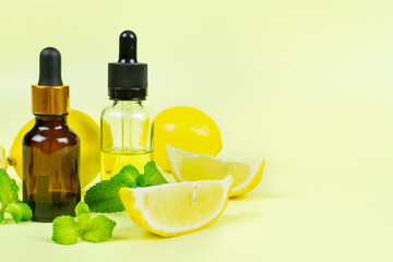 Essential oil of fragrant lemon with mint (peppermint) in a bottle with a pipette on a yellow background. Aromatherapy (anti-fatigue, relaxation), spa, skin care. Space for text.