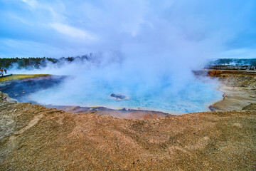Fototapeta na wymiar Dormant geyser and crater at Yellowstone covered in sulfur steam