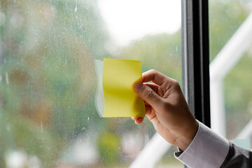 Close-up shot of a person holding a notepad to the glass in a conference room, a startup company meeting room is having a meeting of executives and managers to brainstorm and plan operations.