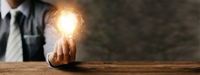 Standing man hold glowing light bulb, Creative new idea. Innovation, brainstorming, strategizing to...