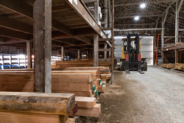 Small town lumberyard with stacks of timber and wood n historical building