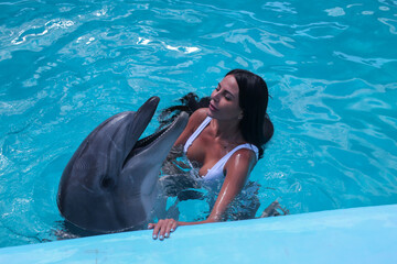 beautiful young girl in the pool with dolphins relax