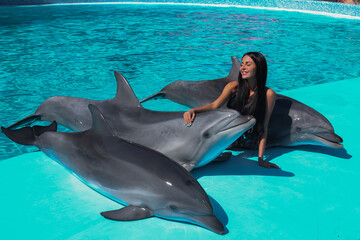 beautiful young girl in the pool with dolphins relax
