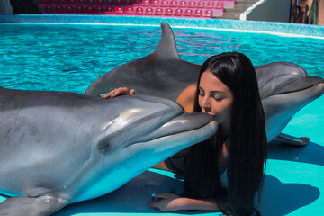 beautiful young girl in the pool with dolphins relax
