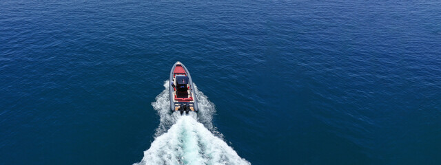 Obraz na płótnie Canvas Aerial drone ultra wide photo of luxury rigid inflatable speed boat cruising in high speed in Aegean deep blue sea, Greece
