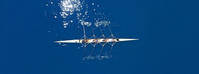 Aerial drone top ultra wide panoramic view of sport canoe rowing synchronous team of athletes...