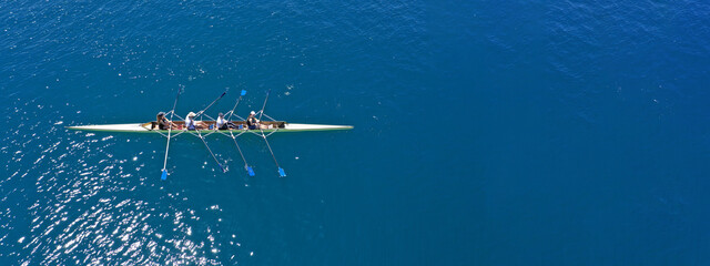 Aerial drone top ultra wide panoramic view of sport canoe rowing synchronous team of athletes...