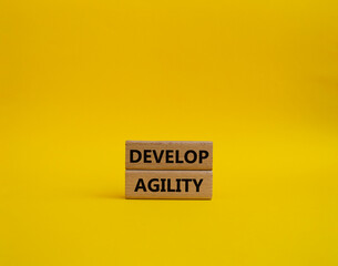 Develop agility symbol. Concept word Develop agility on wooden blocks. Beautiful yellow background. Business and Develop agility concept. Copy space