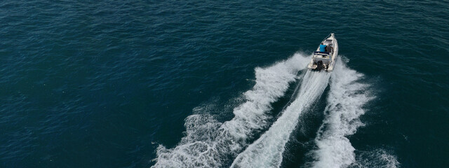 Aerial drone ultra wide photo of luxury rigid inflatable speed boat cruising in high speed in Aegean deep blue sea, Greece