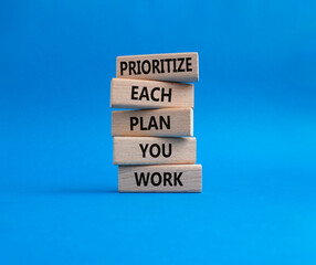 Priority, plan and work symbol. Wooden blocks with words Prioritize each plan you work. Beautiful blue background. Business and Prioritize each plan you work concept. Copy space