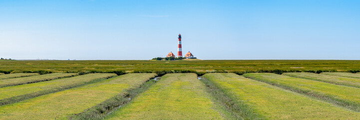 Fototapeta na wymiar Westerheversand Lighthouse along the Salzwiesen (salt marsh), Westerhever, Nordfriesland, Schleswig-Holstein, Germany