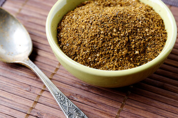 Powder spice blend from black and white mustard seeds and turmeric. Indian mustard powder seasoning in bowl.