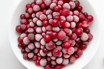 frozen cranberries on a white plate close-up.