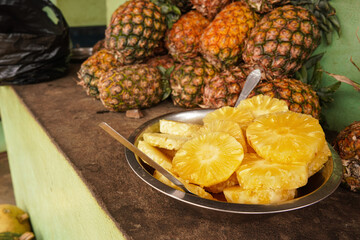 Fresh harvested pineapple on sale near main road in Madagascar, juicy orange fruits ready to eat