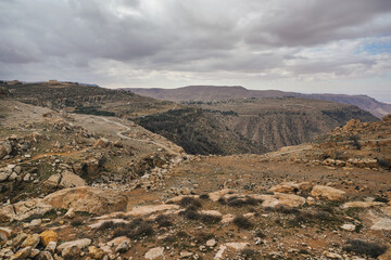Wide panorama of Dana biosphere reserve in Jordan, gray overcast clouds above large canyon