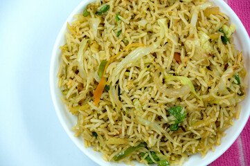 Indian vegetarian pulao or Veg fried rice or Veg Briyabi in brown decorated white bowl with isolated white background. Veg Schezwan Fried Rice ,Vegetarian Szechuan Rice isolated.