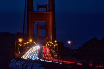 Blurred traffic driving through Golden Gate Bridge at night