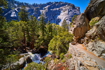 Hiking trail on cliffs overlooking waterfall and stunning Yosemite valley - Powered by Adobe