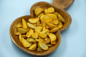Baked potato wedges with spicy coating and deep fried - homemade organic vegetable vegan vegetarian potato wedges snack food meal. Potato wedges isolated white background and ready to eat