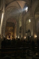 The faithful congregating for Sunday mass under the gray stone Gothic arches of Iglesia de San...