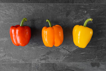 Three pepper on dark background, vegetables for the restaurant, vegetables on a white background