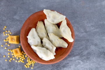 Selective focused Kozhukatta Pidi in mud plate Indian Kerala , Tamilnadu tea time snack steamed food sweet modak rice dumpling for ganesha chathurthi, Diwali, Navratri Dussehra