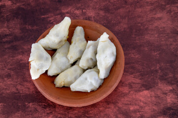 Selective focused Kozhukatta Pidi in mud plate Indian Kerala , Tamilnadu tea time snack steamed food sweet modak rice dumpling for ganesha chathurthi, Diwali, Navratri Dussehra