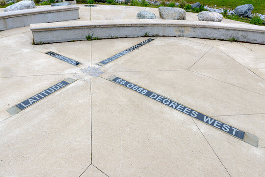 A maple leaf set in concrete marks a latitude and longitude in a park in Saint John, New Brunswick, Canada.