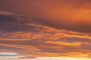 Naklejka na ściany i meble Orange glowing cloud formation during sunset