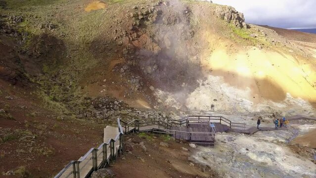 Tourists are walking  on the geothermal area Krysuvik in the Reykjanes peninsula not far from Reykjavik, Iceland