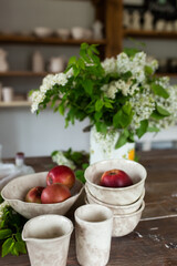 Apples on wooden plate with fresh summer flowers