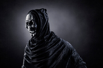 Grim reaper over dark misty background