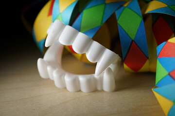 Brightly colored carnival streamers seen in detail with vampire false teeth. holiday background...