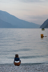 The boy looks at the river, Riva del Garda, Italy