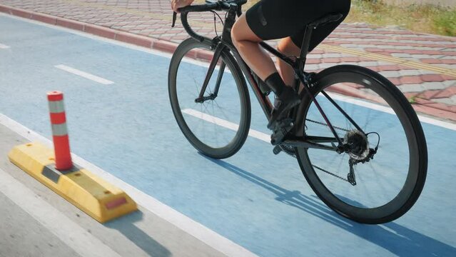 Fit Female Legs In Cycling Shoes Riding On Road Bicycle On Bike Lane, Close Up