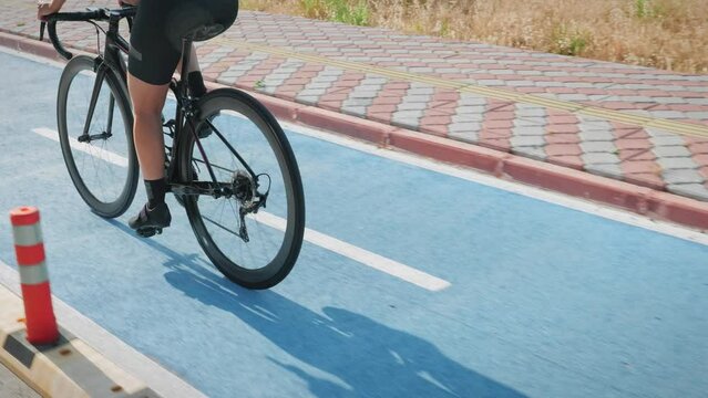 Female Cyclist Riding Bicycle On Bike Lane, Muscular Fit Legs In Cycling Shoes