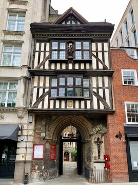 St. Bartholomew’s Gatehouse in City of London.  Street view of City of London. Medieval half-timbered house with arched gate to St. Bartolomeo the Great church. Selective focus. Vertical