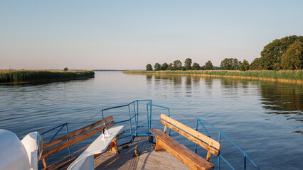 Obraz premium Landscape with boat front and river delta on a warm summer evening.