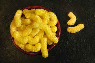 Corn sticks in a cup on a black background, top view. Selective focus with copy space